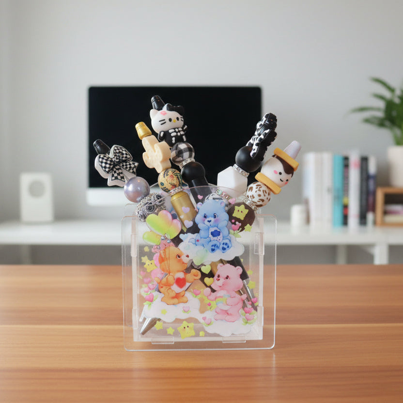 Clear badge holder with colorful cartoon characters and decorative pens on a desk.