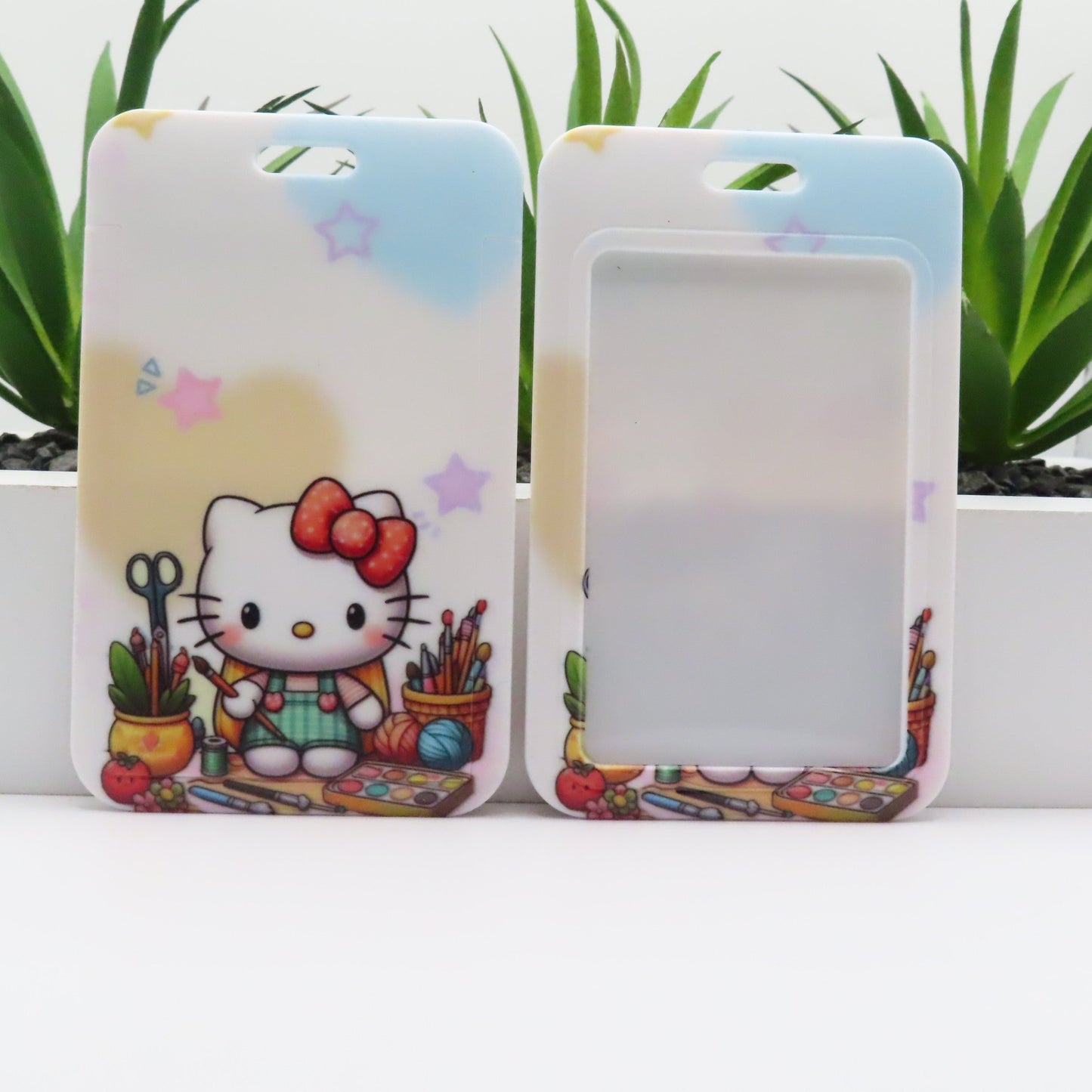 Two phone cases with a cartoon character and colorful design on a white surface with plants in the background.