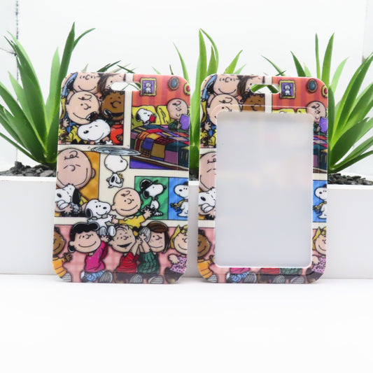 Phone case with cartoon design featuring characters and a colorful background, placed on a white surface with green plants.