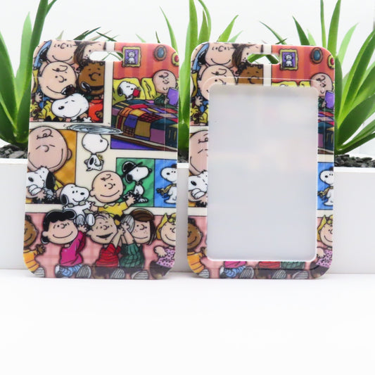 Phone case with cartoon design featuring characters and a colorful background, placed on a white surface with green plants.