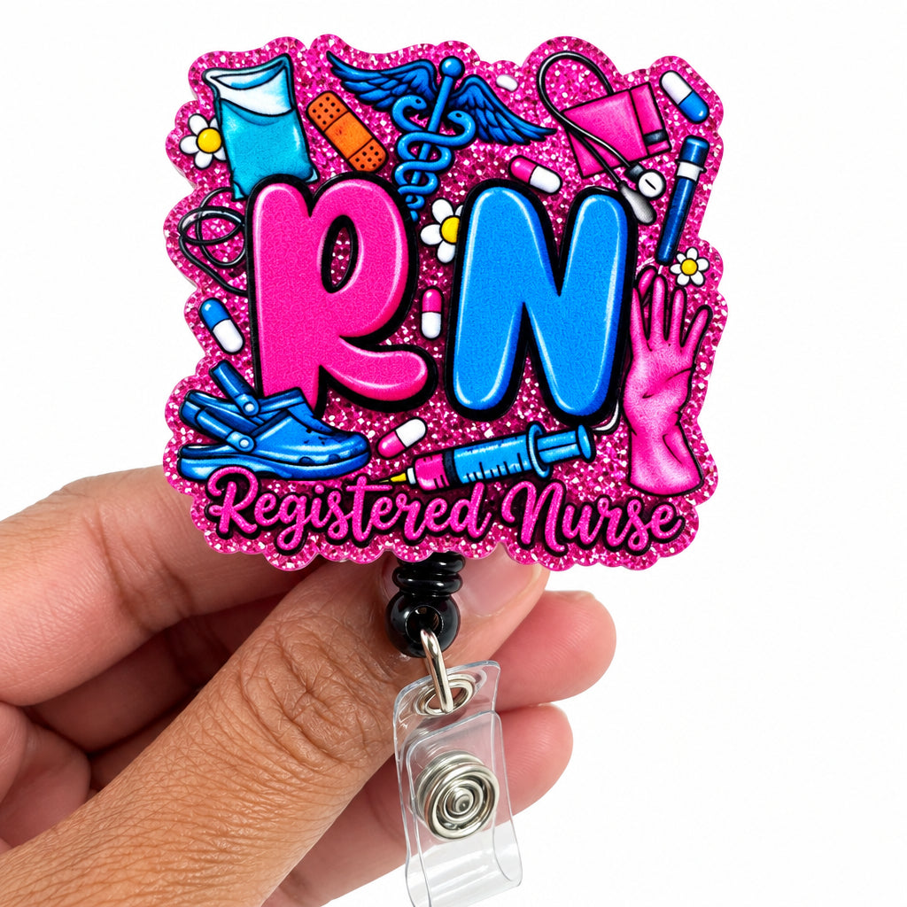 A hand holding a pink glitter 'RN Registered Nurse' badge reel. The badge features large pink and blue letters 'RN' surrounded by medical icons like a stethoscope, syringe, and clipboard on a white background.