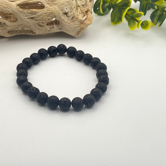 Black beaded bracelet on a white surface with decorative elements