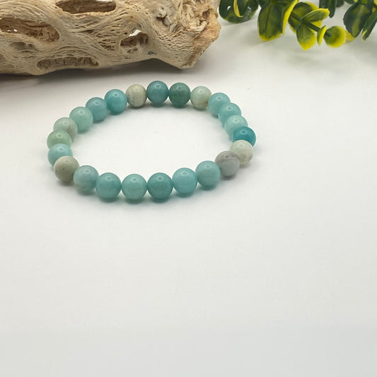 Turquoise beaded bracelet on a white background with natural elements.