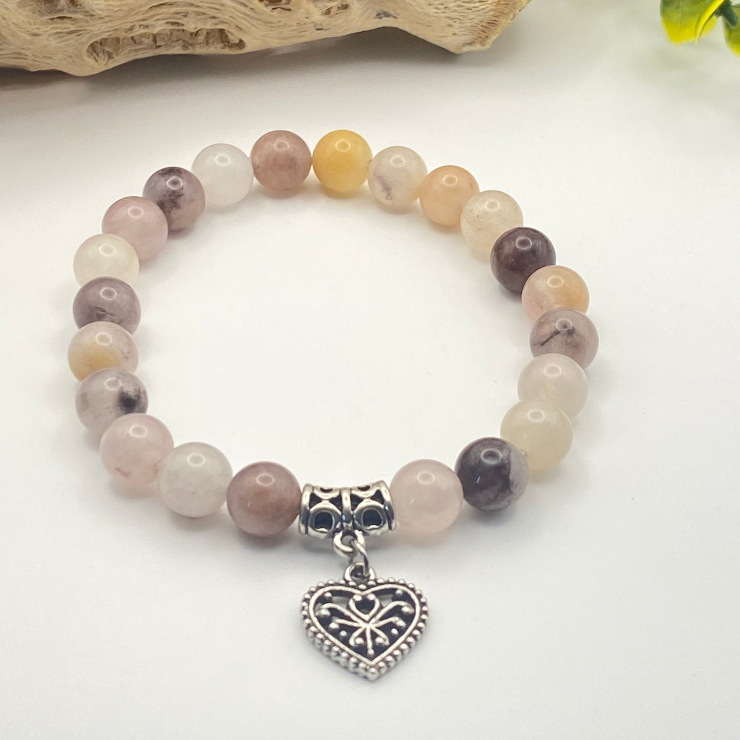 Beaded bracelet with a heart-shaped charm on a white background