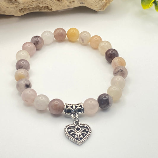 Beaded bracelet with a heart-shaped charm on a white background