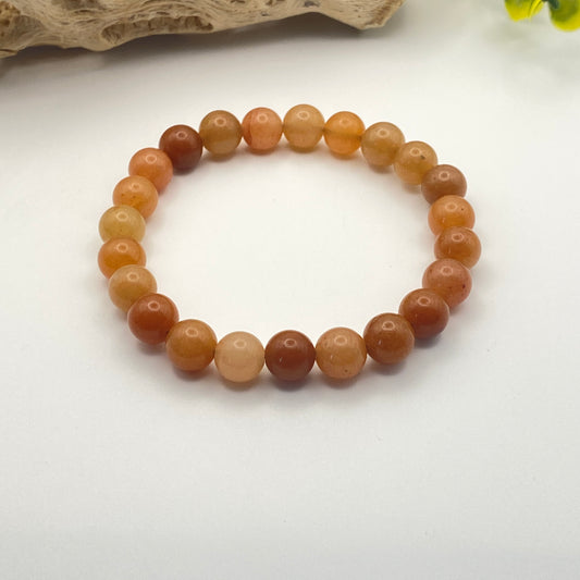Round beaded bracelet with brown and beige stones on a white background