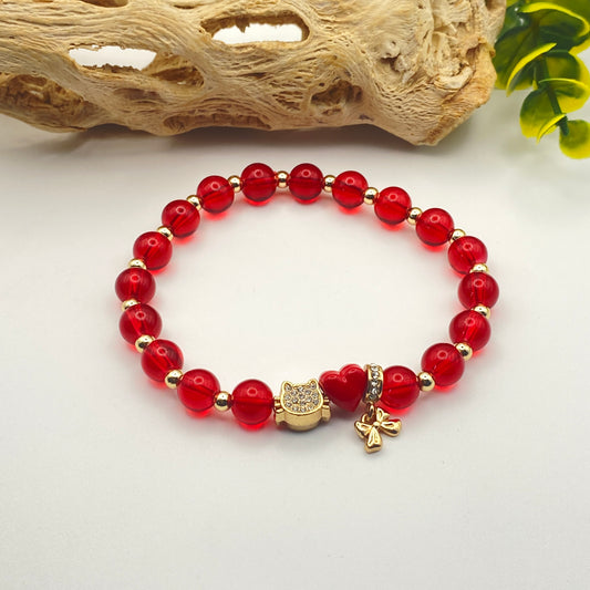 Red beaded bracelet with gold accents on a white background