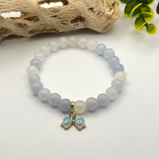 Beaded bracelet with a heart-shaped charm on a white surface