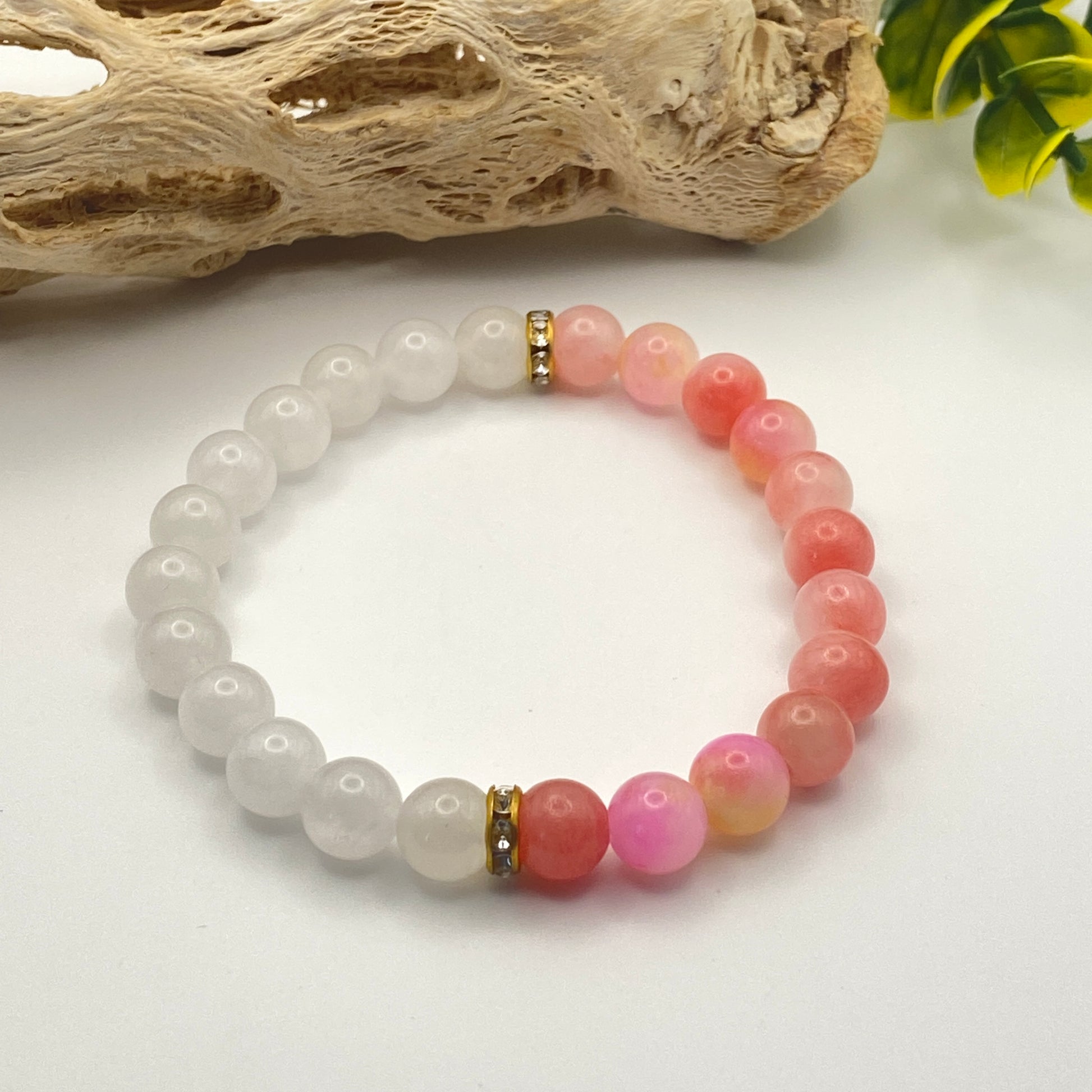 Beaded bracelet with white, pink, and red beads on a white background