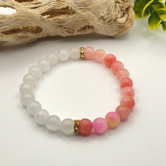 Beaded bracelet with white, pink, and red beads on a white background