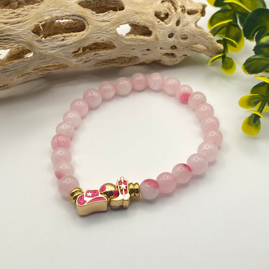 Pink beaded bracelet with a gold clasp on a white background