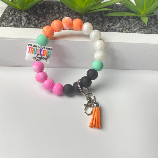 Colorful beaded bracelet with a tassel charm on a white surface