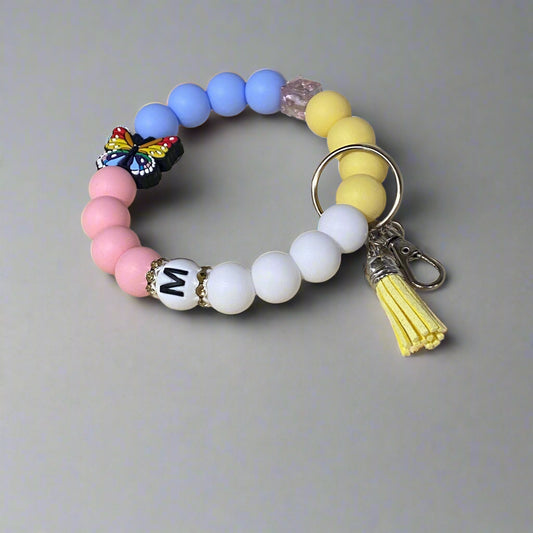 Colorful beaded keychain with a tassel on a beige background