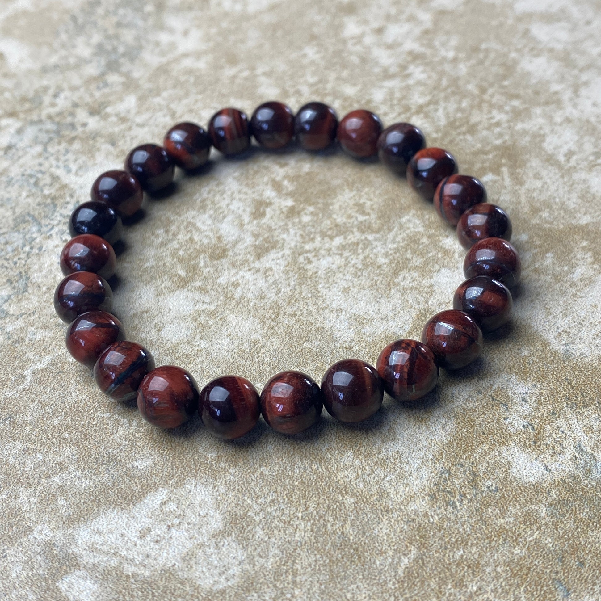 Brown beaded bracelet on a textured beige surface