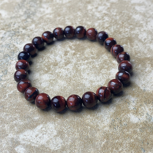 Brown beaded bracelet on a textured beige surface