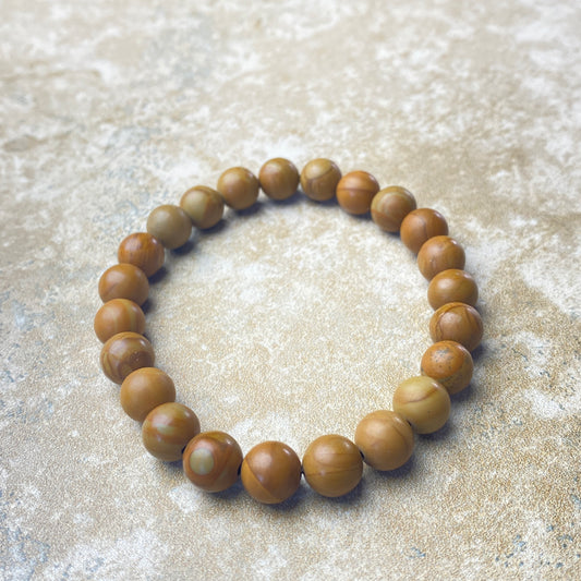 Wooden beaded bracelet on a textured beige surface