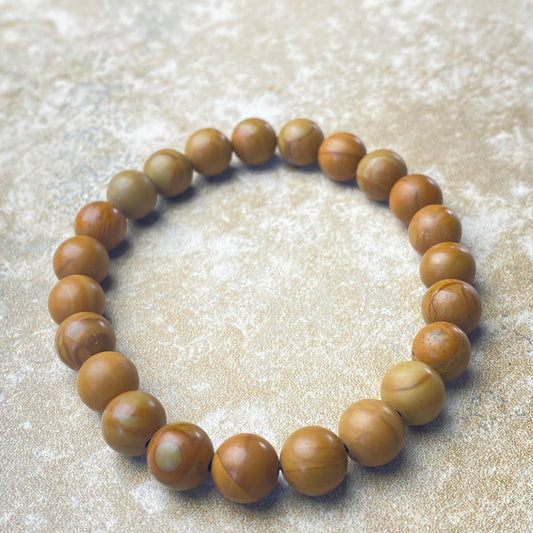 Wooden beaded bracelet on a textured beige surface
