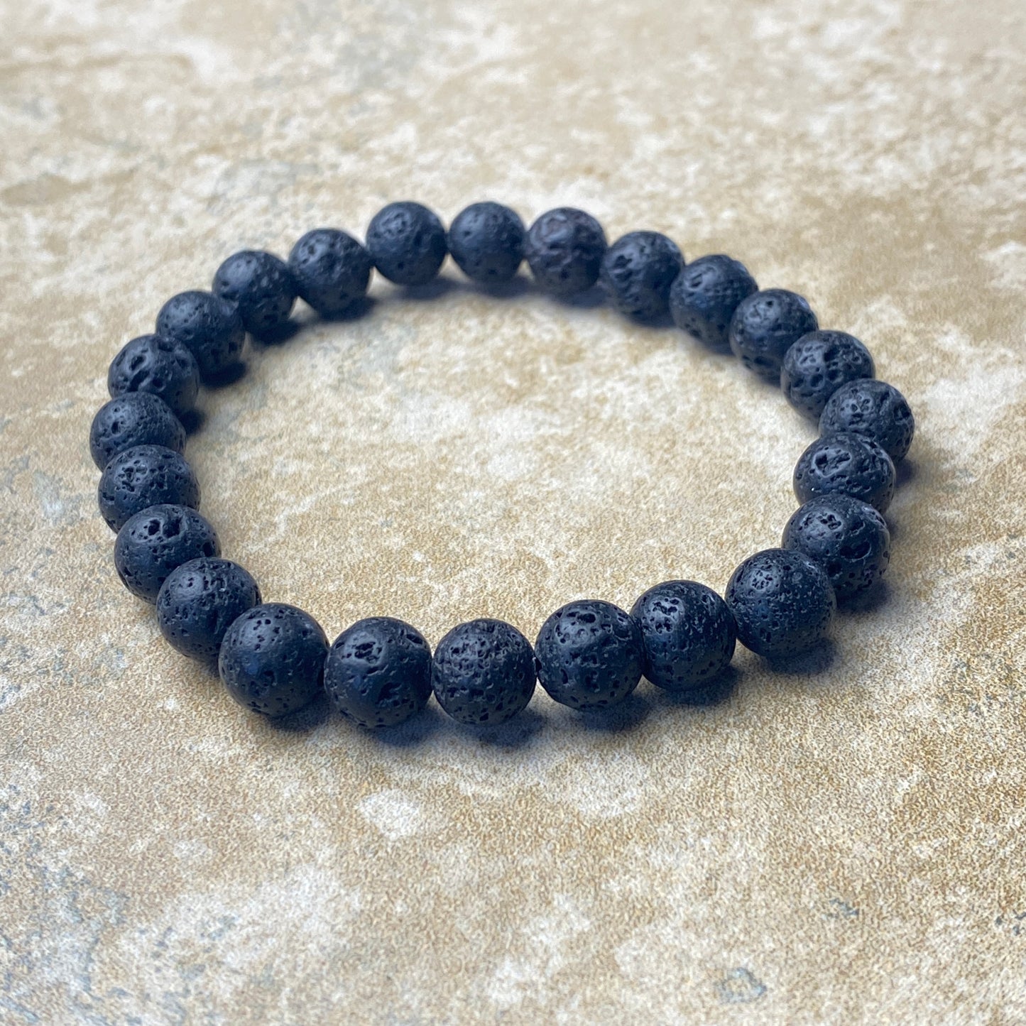 Lava stone bracelet on a textured surface