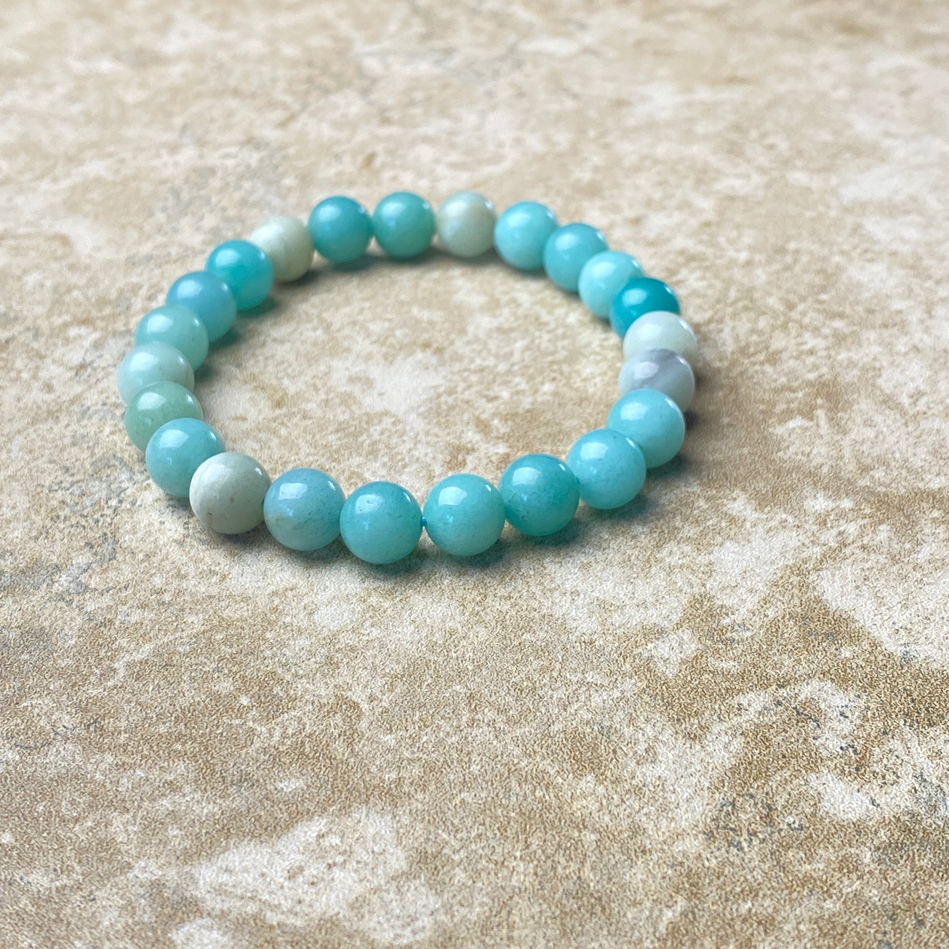 Beaded bracelet with blue and white beads on a textured beige surface