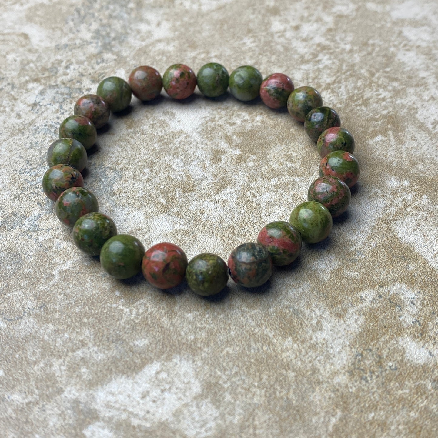 Green beaded bracelet on a textured surface
