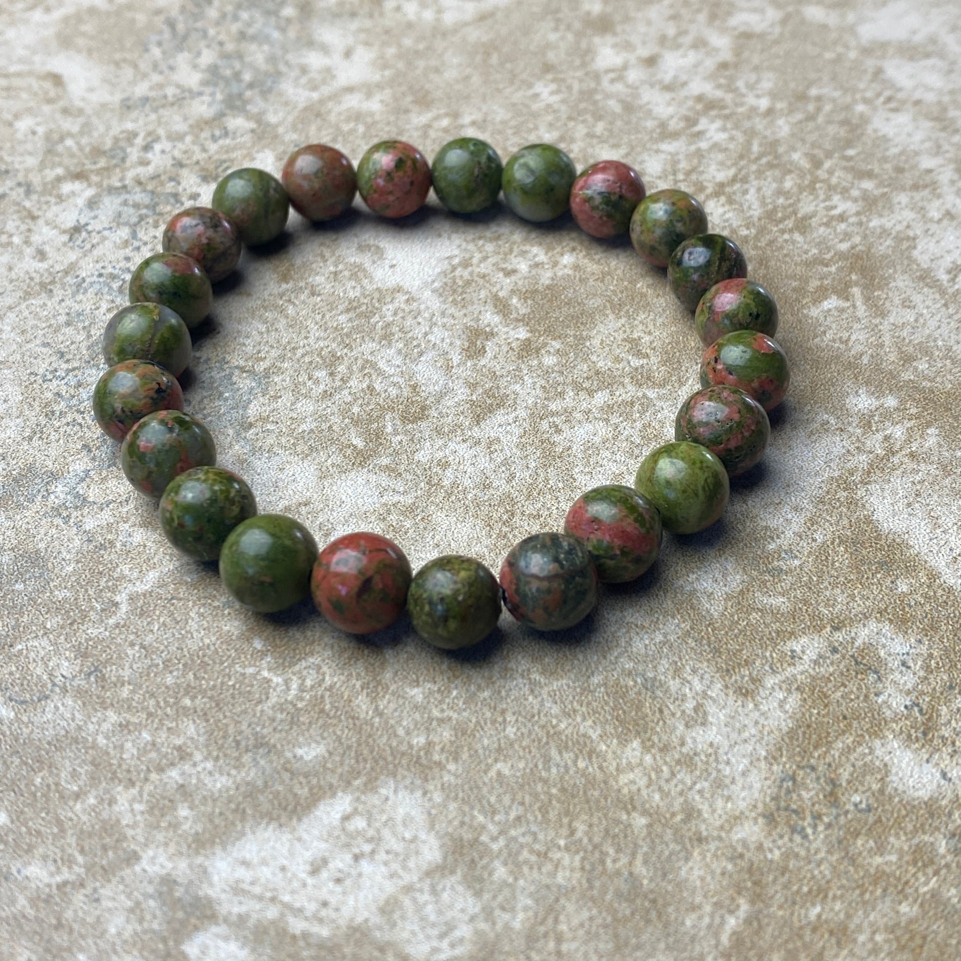 Green beaded bracelet on a textured surface