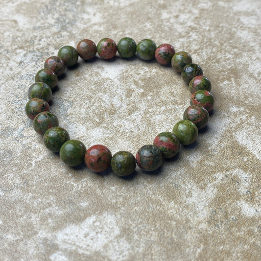 Green beaded bracelet on a textured surface