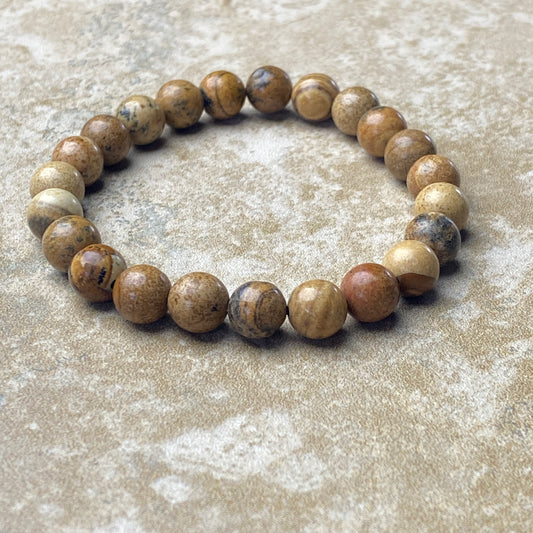 Beaded bracelet with brown and beige stones on a textured surface