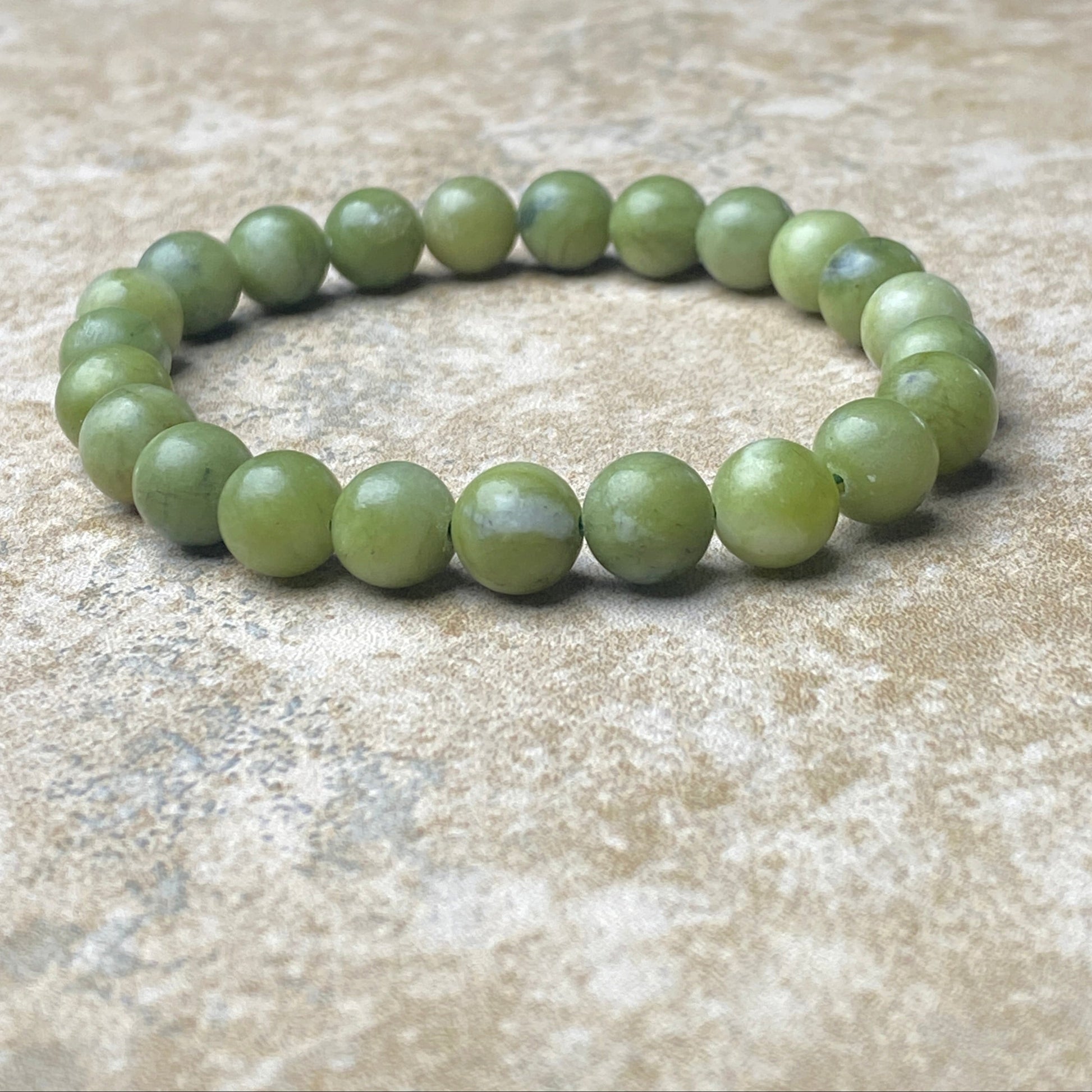 Green beaded bracelet on a textured surface