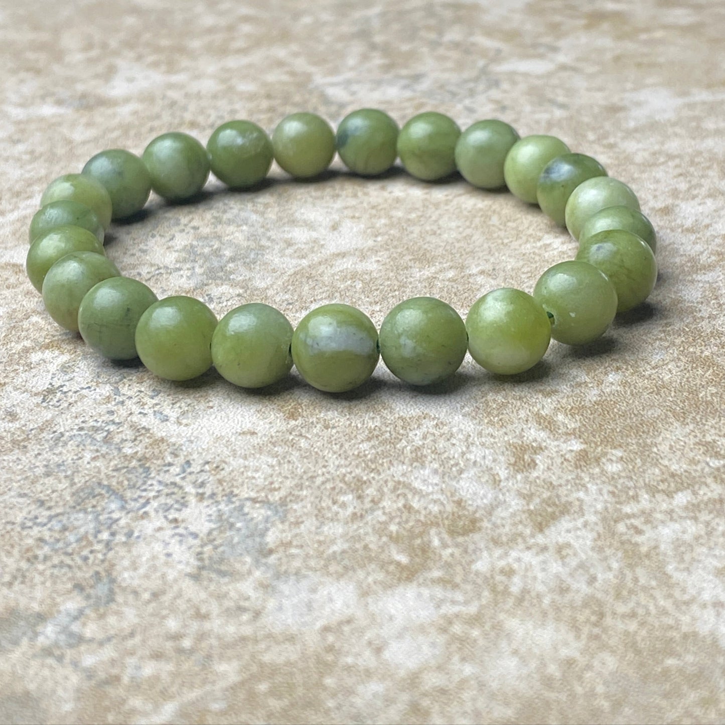 Green beaded bracelet on a textured surface