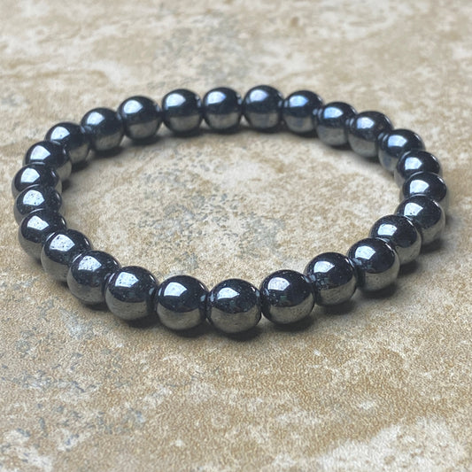 Black beaded bracelet on a beige surface