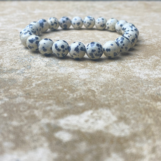 Bracelet with blue and white speckled beads on a beige surface