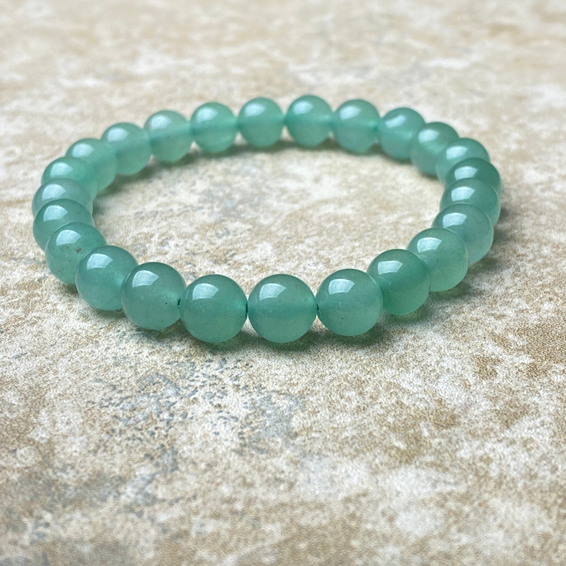 Green beaded bracelet on a textured surface