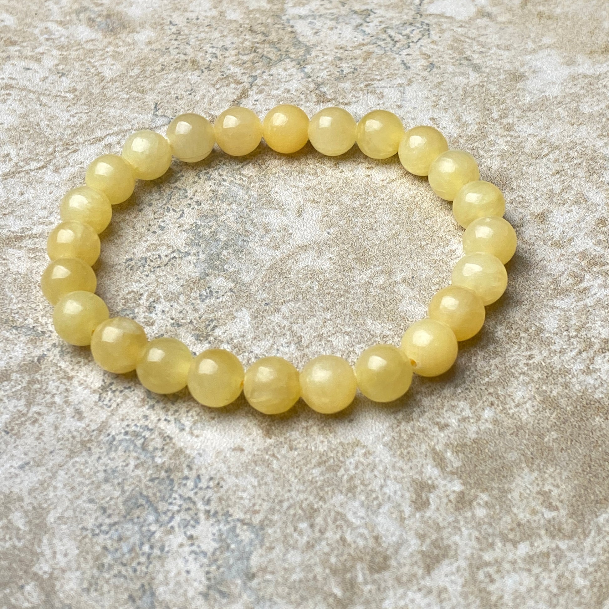 Yellow beaded bracelet on a textured stone surface