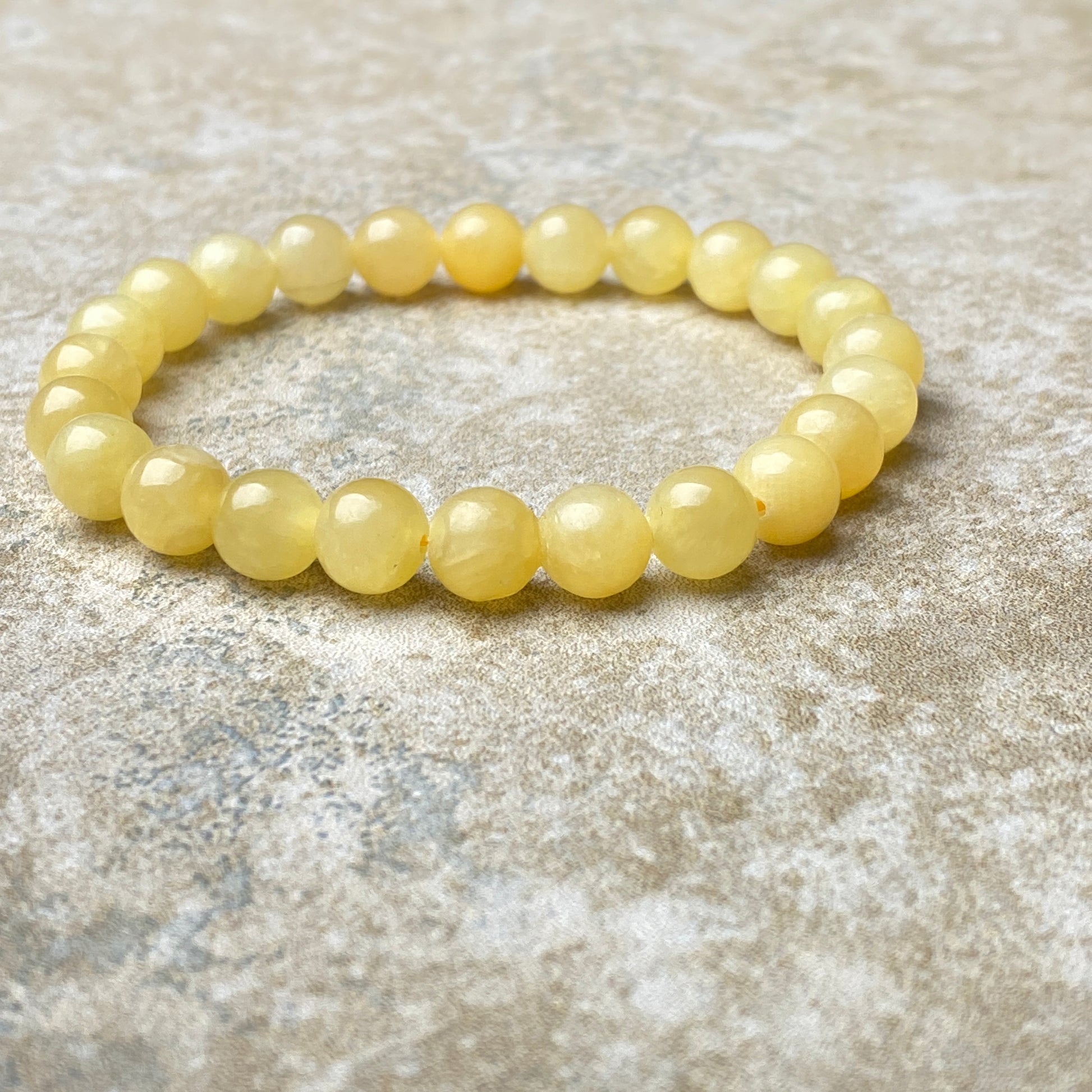 Yellow beaded bracelet on a textured surface
