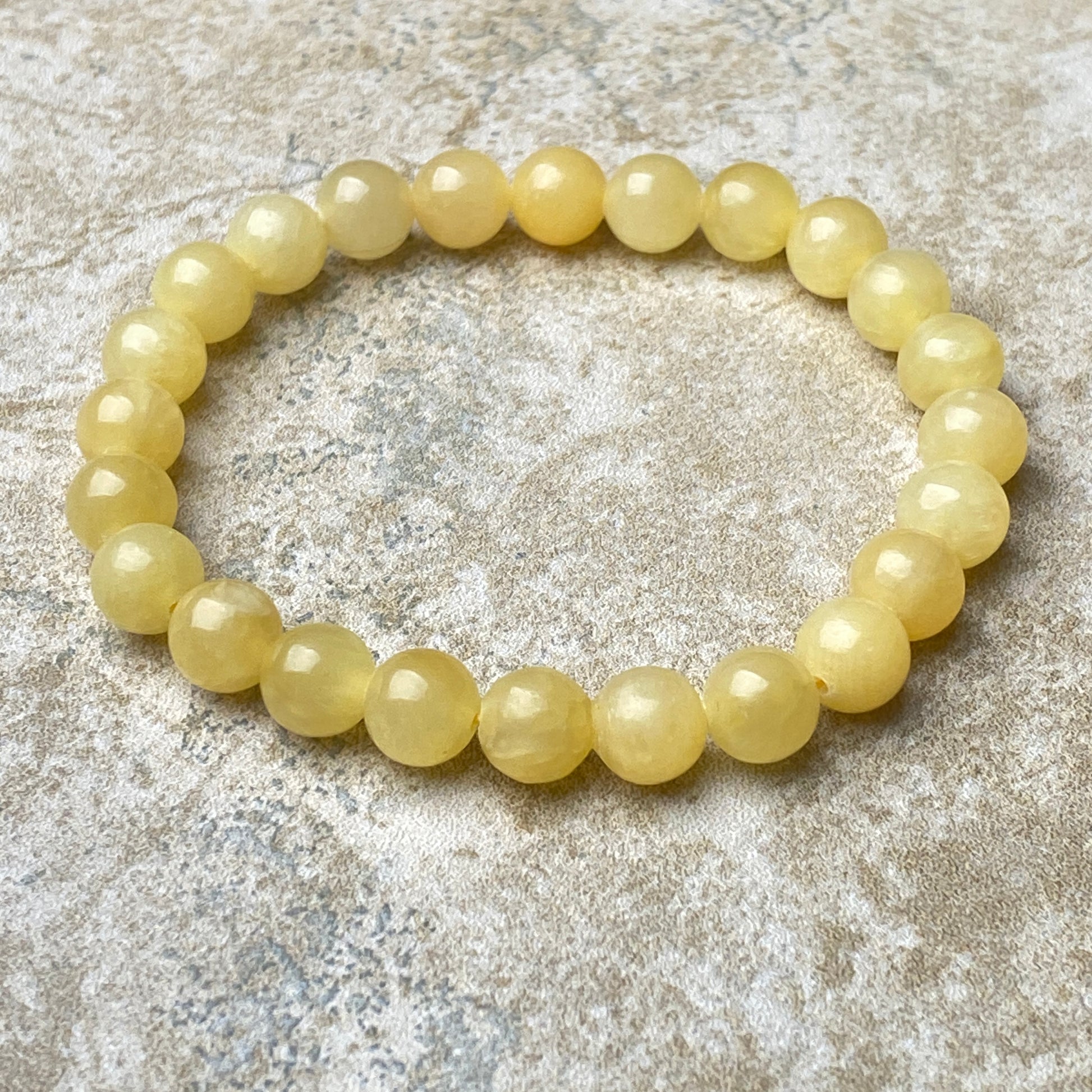 Yellow beaded bracelet on a textured stone surface