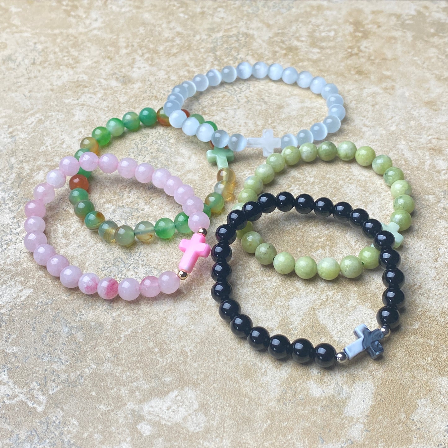 Set of beaded bracelets with crosses on a beige surface