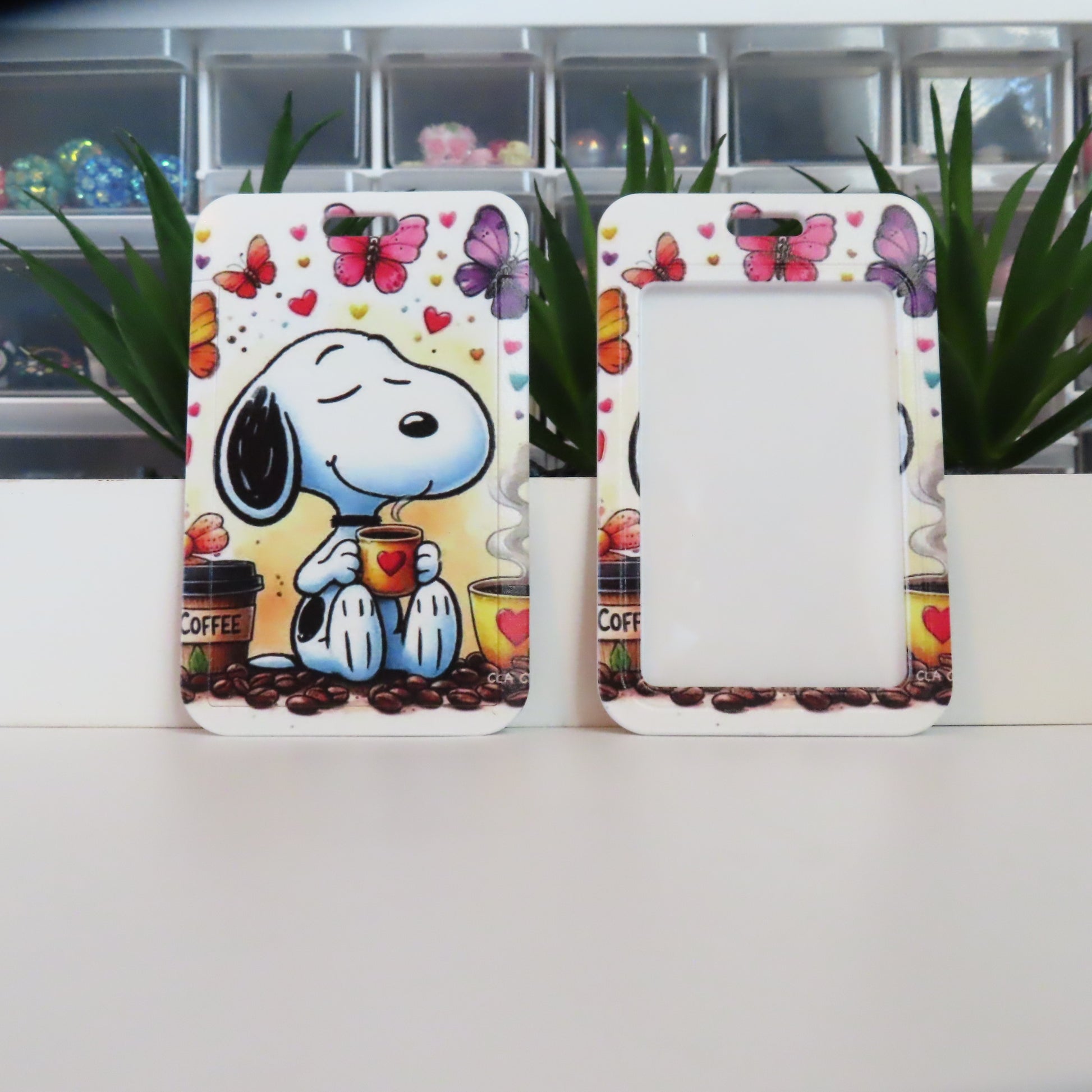 Two decorative picture frames featuring Snoopy holding a coffee cup with a colorful butterfly design.