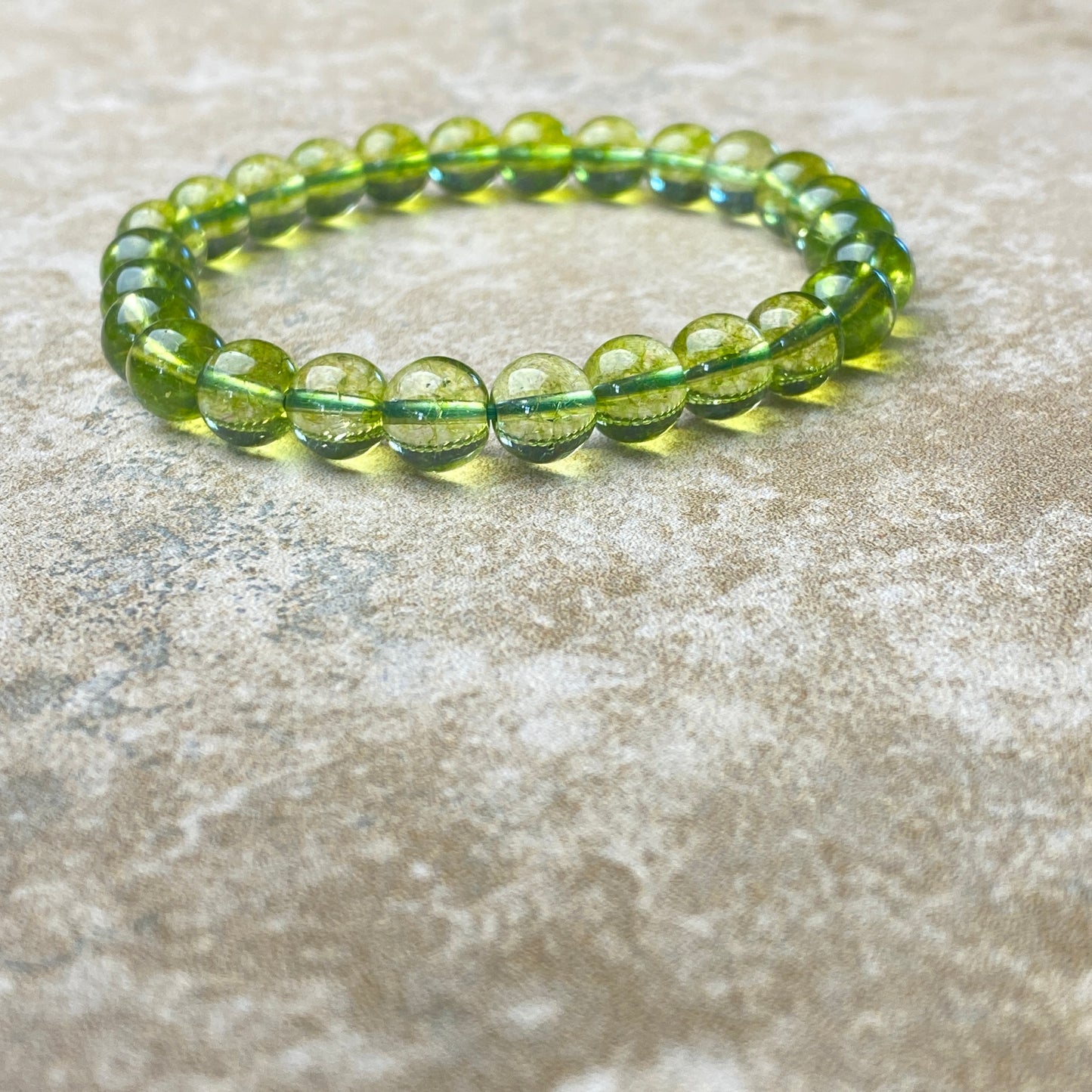 Green beaded bracelet on a textured surface