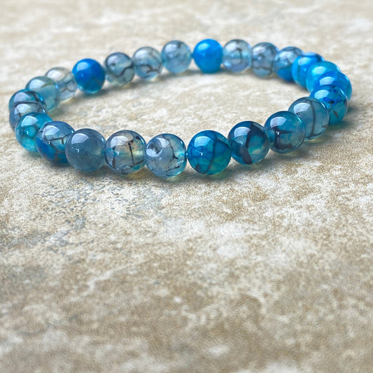 Blue beaded bracelet on a textured surface