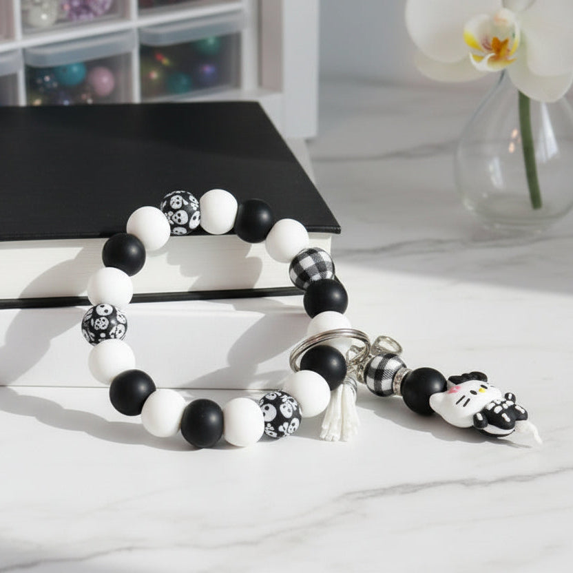 Black and white beaded bracelet with panda charm on a light surface