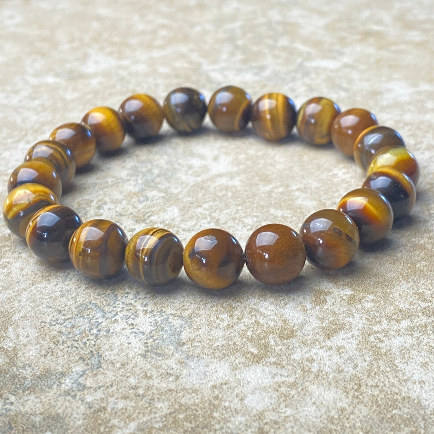 Beaded bracelet with tiger eye stones on a textured surface