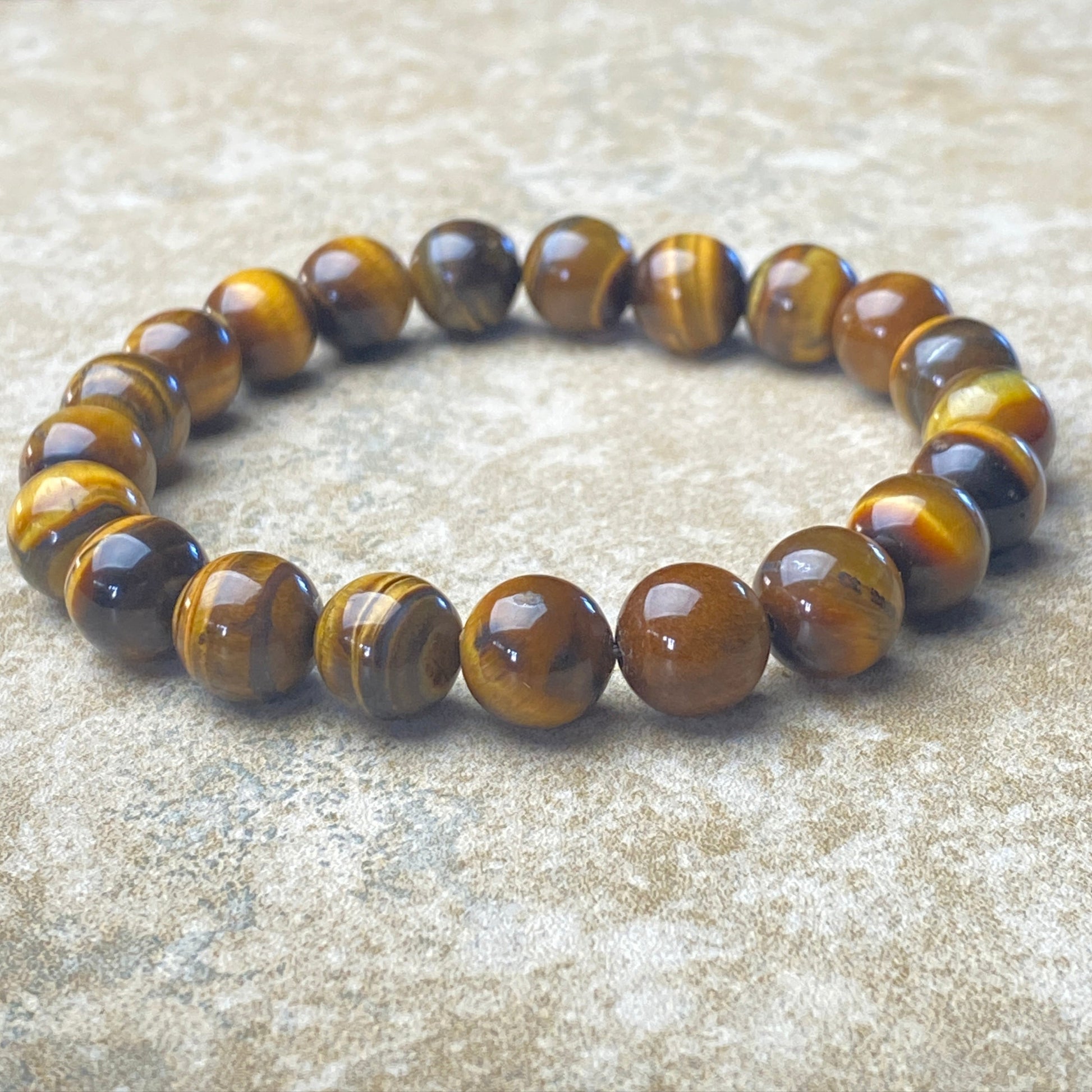 Beaded bracelet with tiger eye stones on a textured surface