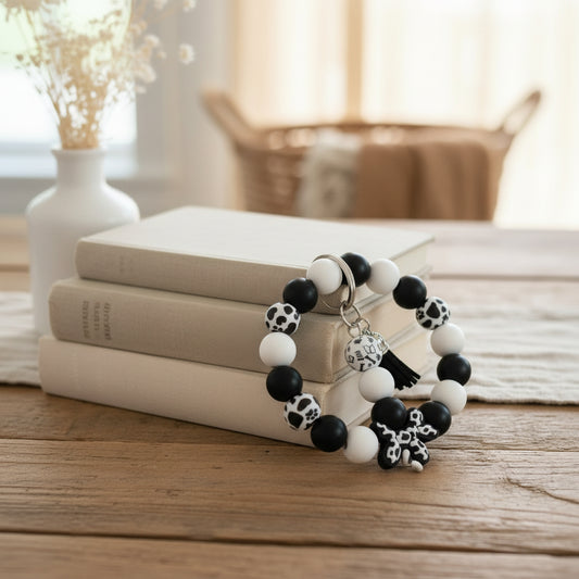 Black and white beaded bracelet with charms on a white surface