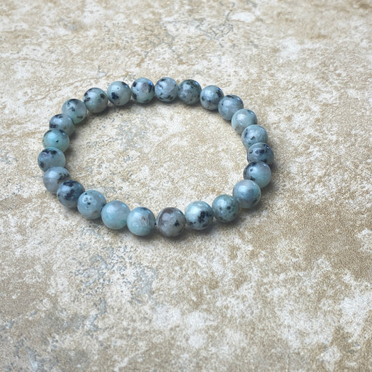Blue beaded bracelet on a textured beige surface