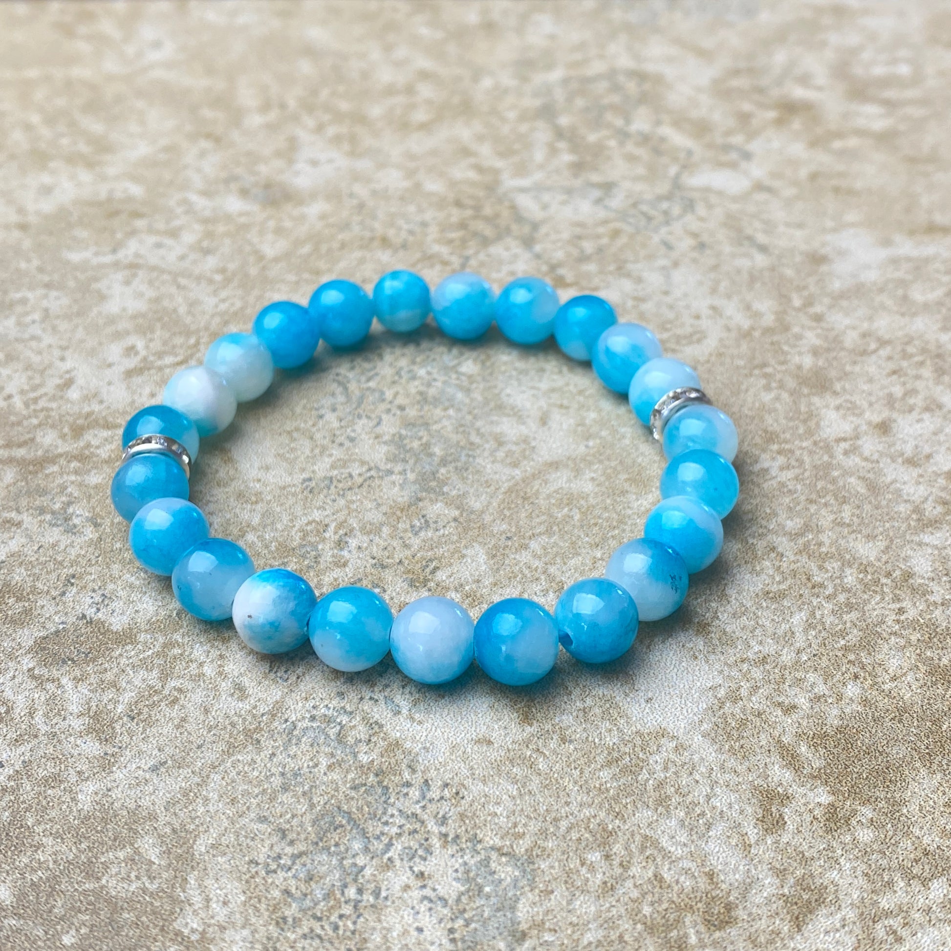 Blue beaded bracelet on a textured beige surface