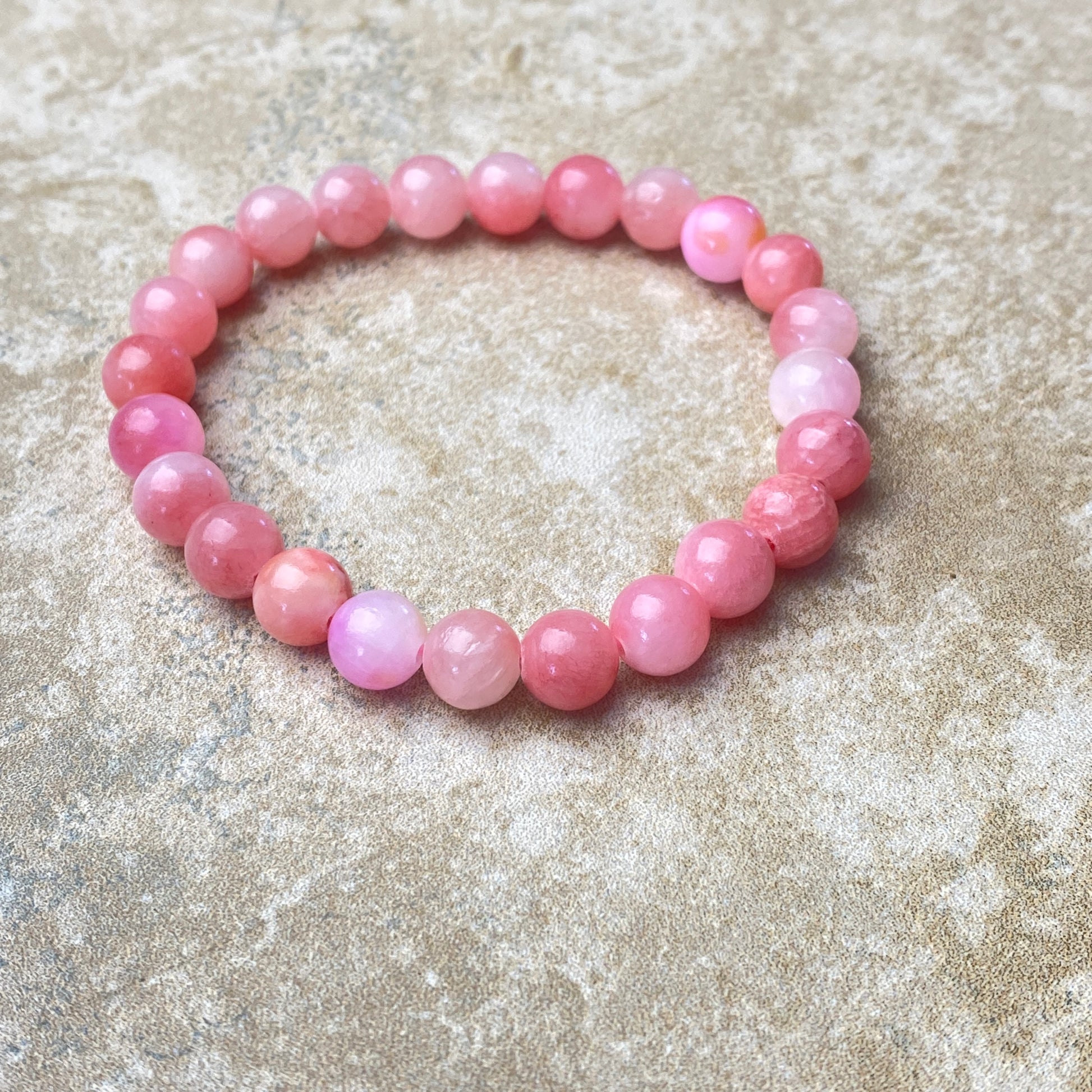 Pink beaded bracelet on a textured surface