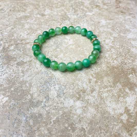 Green beaded bracelet on a textured stone surface