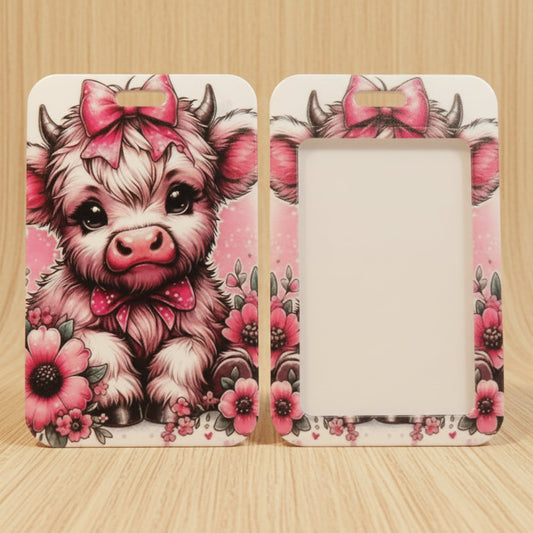 A pair of decorative picture frames shown front and back on a light wood surface. The frames feature a cute cartoon cow illustration with a pink bow and floral border, with one frame displaying a blank white insert area.
