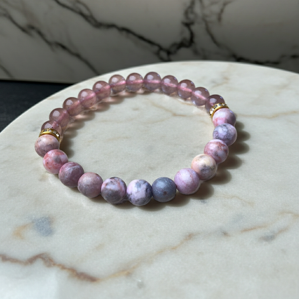 Pink and purple beaded bracelet on a marble surface