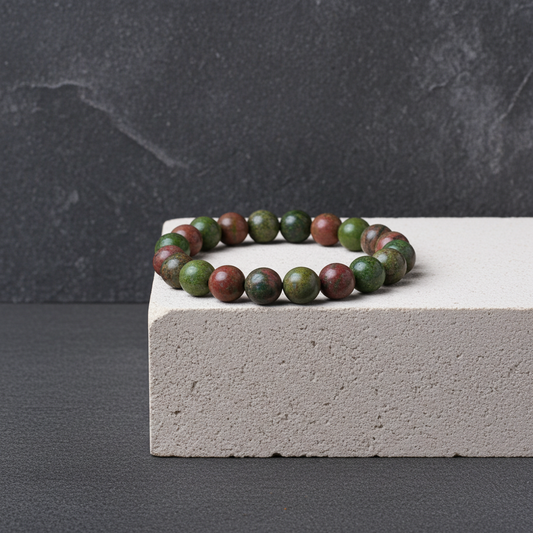 Bracelet with green and brown beads on a gray surface